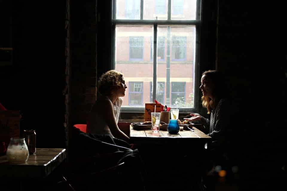 duas mulheres conversando num restaurante